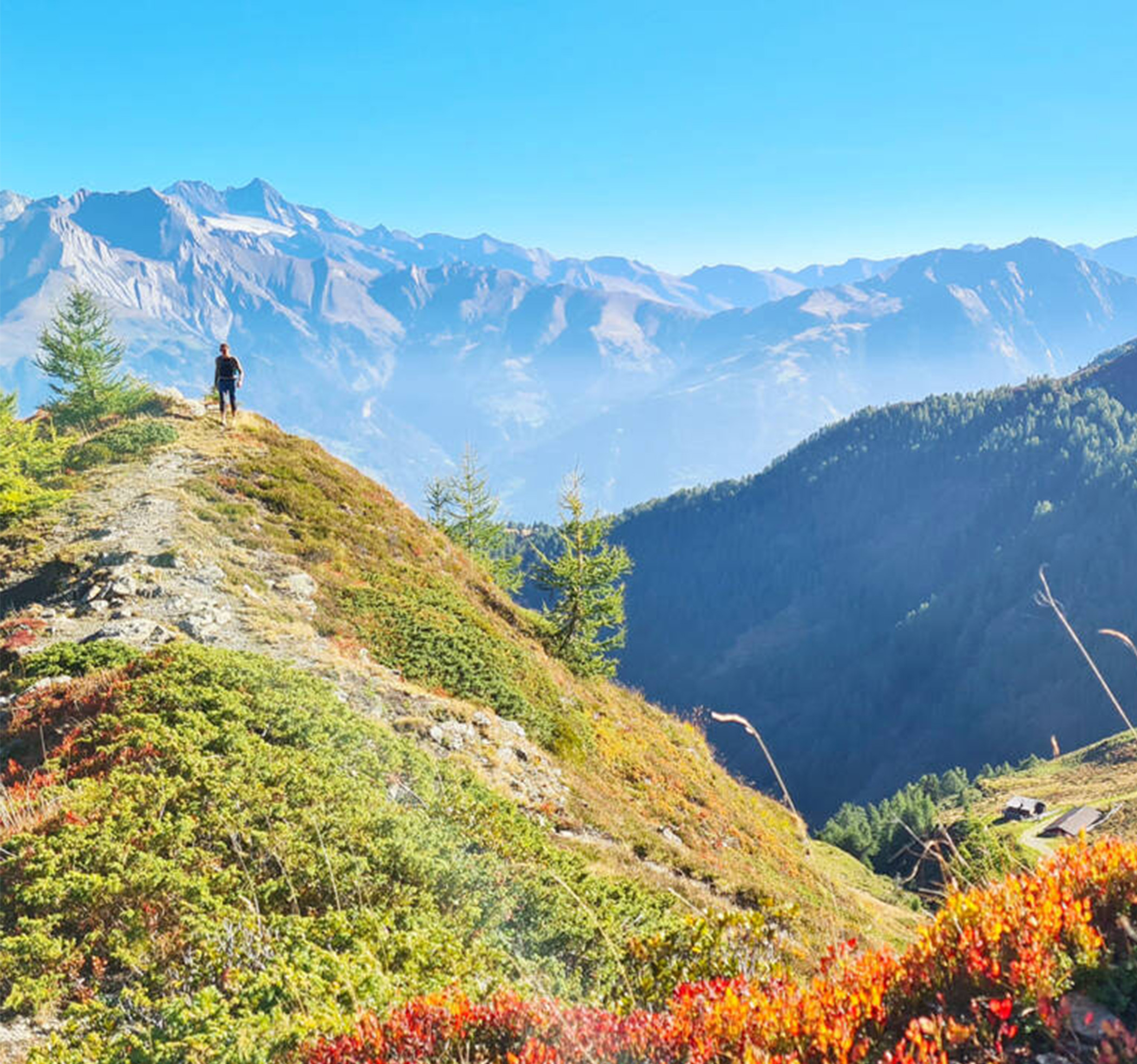 Woman hiking along the ridge in autumn with mountain panorama in the background - Hotel Ortnerhof