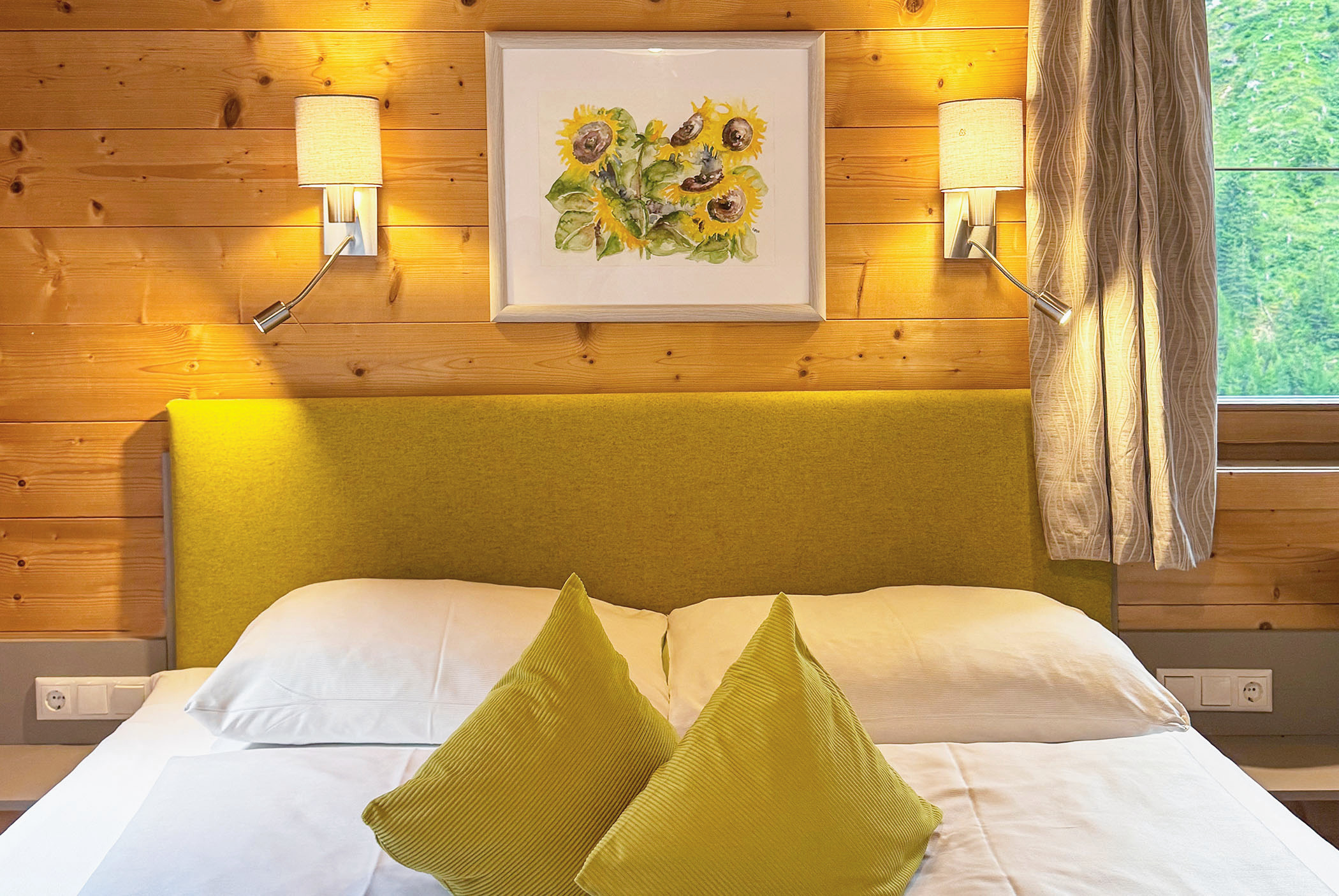 Doppelbett mit Kopfteil aus Stoff - Holzvertäfelung an der Wand - Hotel Ortnerhof