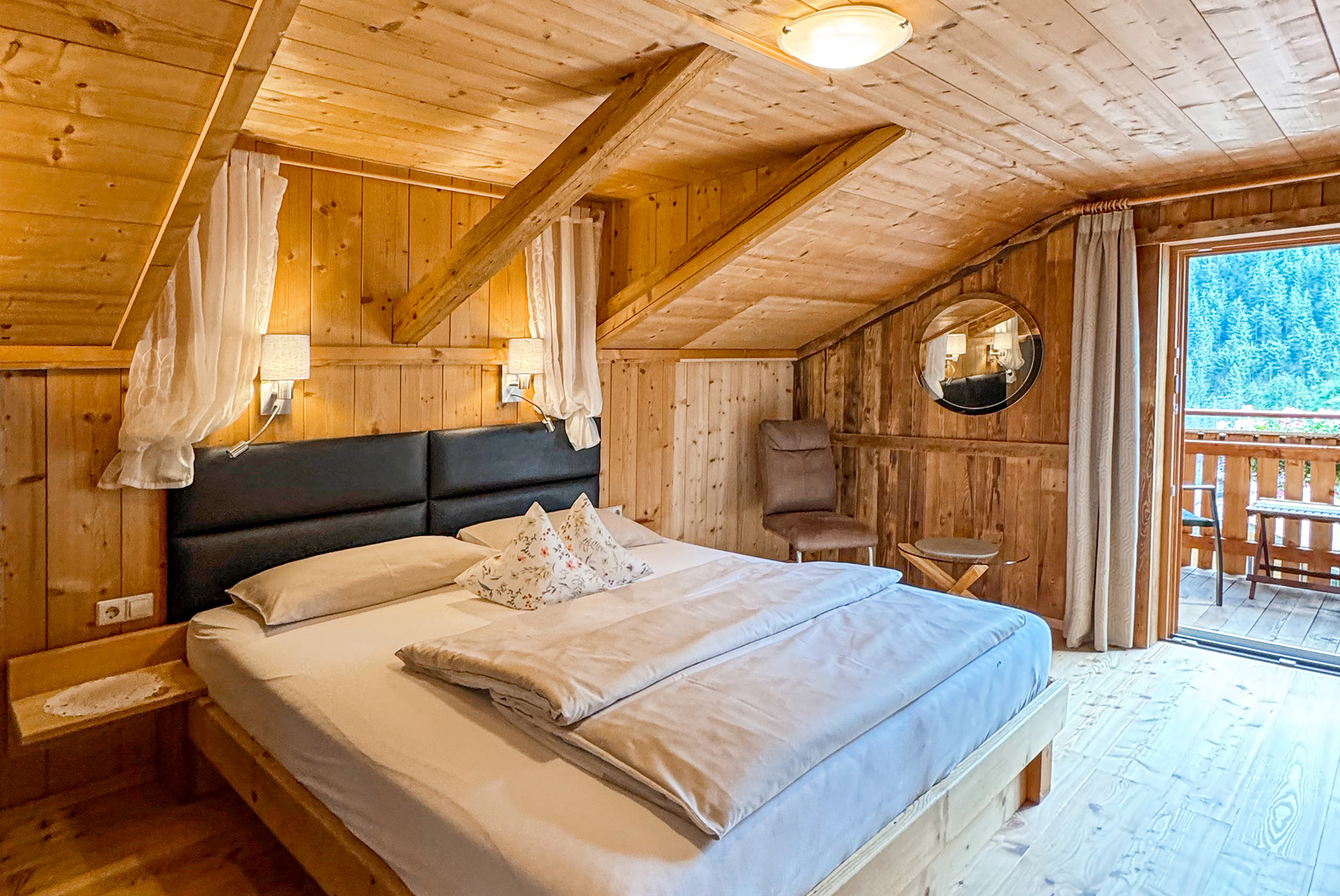 Zimmer mit Doppelbett, Lesesessel und Ausblick auf Balkon - Hotel Ortnerhof